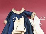 a blue dress and brown boots on a pink background
