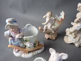 four figurines of children sitting on a sled