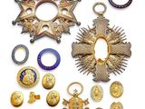 une image représentant une collection de médailles et d'autres objets posés sur une surface blanche