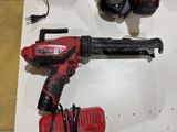 a corded drill and two other tools on a table