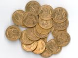 a pile of gold coins sitting on a white surface
