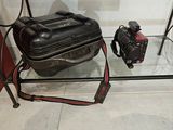 une valise et un appareil photo posés sur une table en verre