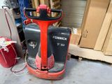 un chariot élévateur rouge et noir garé dans un garage
