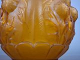 a yellow glass vase with a handle on a table