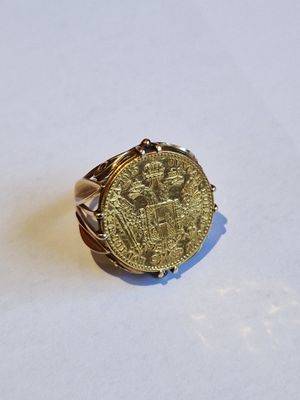 Gros plan sur une bague ornée d'une pièce d'or