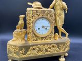 une horloge en or sur laquelle figurent un homme et une femme