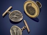 trois boutons de manchette en argent et une pièce de monnaie sur fond bleu