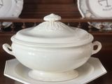 un bol blanc avec un couvercle posé sur une assiette