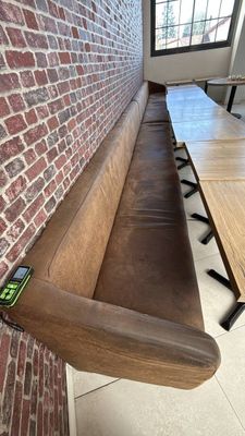 un banc en bois situé près d'un mur en briques