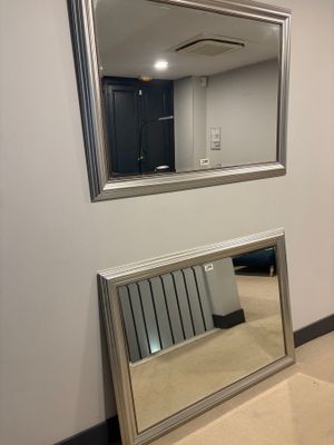 a mirror on the wall next to a radiator in a room