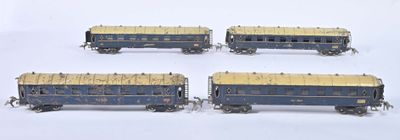 four blue and gold train cars sitting on a white surface