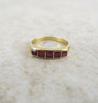 une photo d'une bague en or sertie de pierres roses