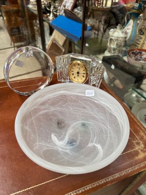 a glass bowl on a table with a clock in it