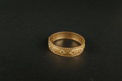a close up of a gold ring on a black surface