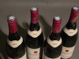 six bottles of red wine are lined up on a table
