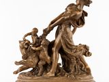 une statue antique en bronze représentant une femme accompagnée d'un chien et d'un homme