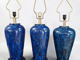 three blue vases are lined up against a white background