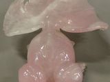 a pink glass figurine with a leaf on top of it