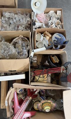 de nombreux cartons d'objets hétéroclites posés sur le sol