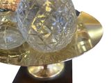 a glass vase on a metal stand with a gold base
