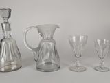 quatre verres à vin et une carafe posés sur une table
