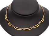 un collier en or autour du cou d'un mannequin coiffé d'un chapeau noir