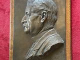 a plaque of a man with a mustache on a red wall