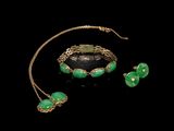 une photo d'un ensemble composé d'un collier, d'un bracelet et de boucles d'oreilles ornés de perles de verre vertes