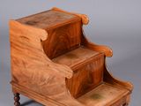an antique wooden step stool with two steps on each side