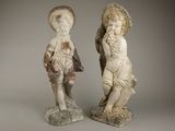 Deux statues représentant un garçon et une fille se tiennent l'une à côté de l'autre.