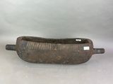 a small wooden boat with a handle on a table