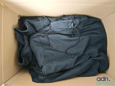 a black shirt in a cardboard box with a black hoodie