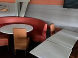 tables and chairs in a restaurant with a flat screen tv on the wall