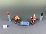 three figurines of people sitting in chairs next to each other