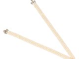 un gros plan d'un collier de perles blanches sur fond blanc