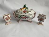 three pieces of pottery sitting on a white surface