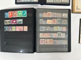 a lot of stamps on a black folder on the wall