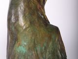 bronze sculpture of a woman sitting on a chair