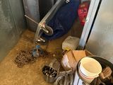 a trash can and a bucket in the corner of a room