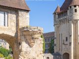 un bâtiment en pierre avec une tour et un portail devant
