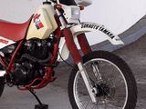 a red and white dirt bike parked in a garage