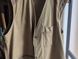 un gilet beige suspendu à un portant dans une pièce