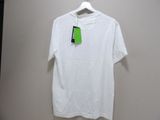 white t - shirt hanging on a hanger with a green tag