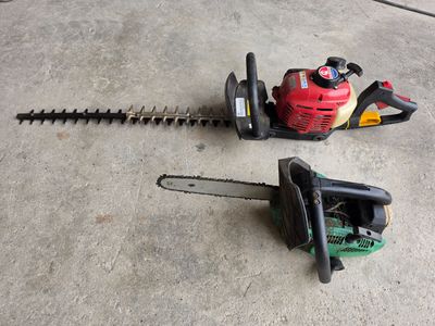 two chainsaws sitting on the ground next to each other