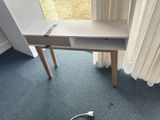 a small desk with a computer on it in the corner of a room