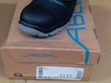 black leather school shoes in a box on top of a cardboard box