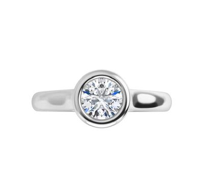 un gros plan d'une bague en diamant sur fond blanc
