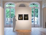 a sculpture of a man standing in a room with two paintings on the wall