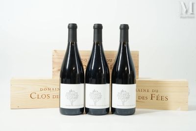 trois bouteilles de vin dans une caisse en bois, avec une autre caisse en bois derrière elles