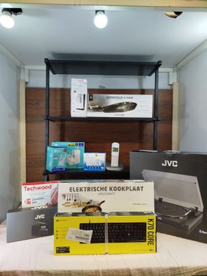 a table with a laptop, keyboard, mouse, and other electronics on it